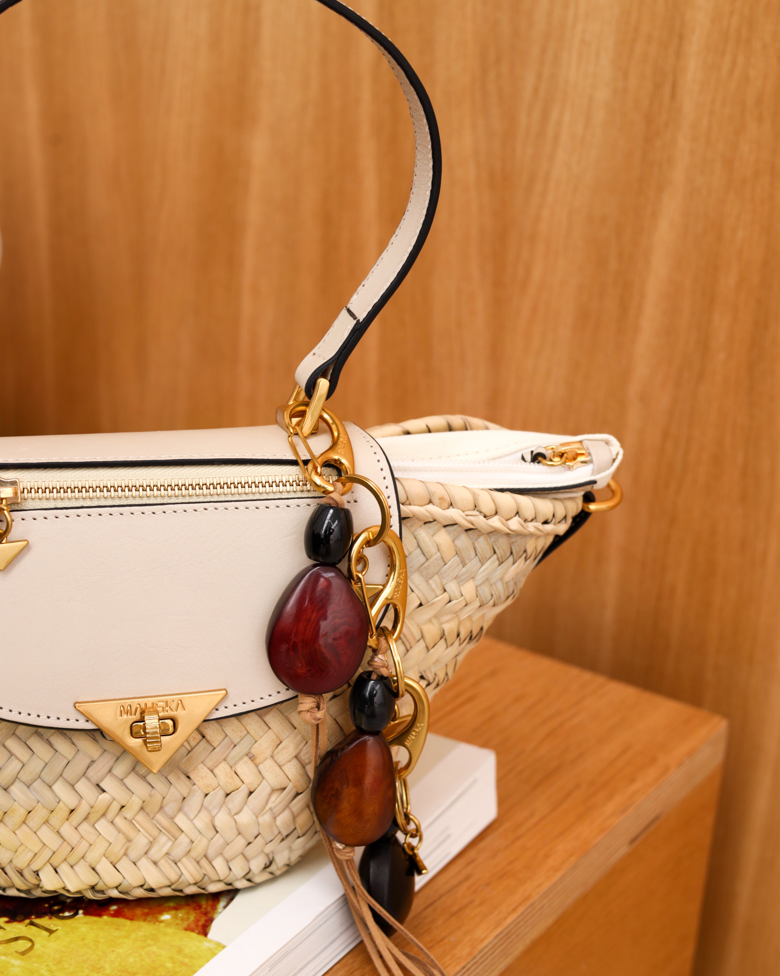 Detalle del charm llavero de piel modelo Tagua de la firma Mauska. Accesorio de micro-marroquinería de lujo diseñado en San Sebastián y fabricado artesanalmente por maestros marroquineros en Ubrique, España. Se aprecia la calidad premium de la piel y el acabado de los herrajes de alta gama.