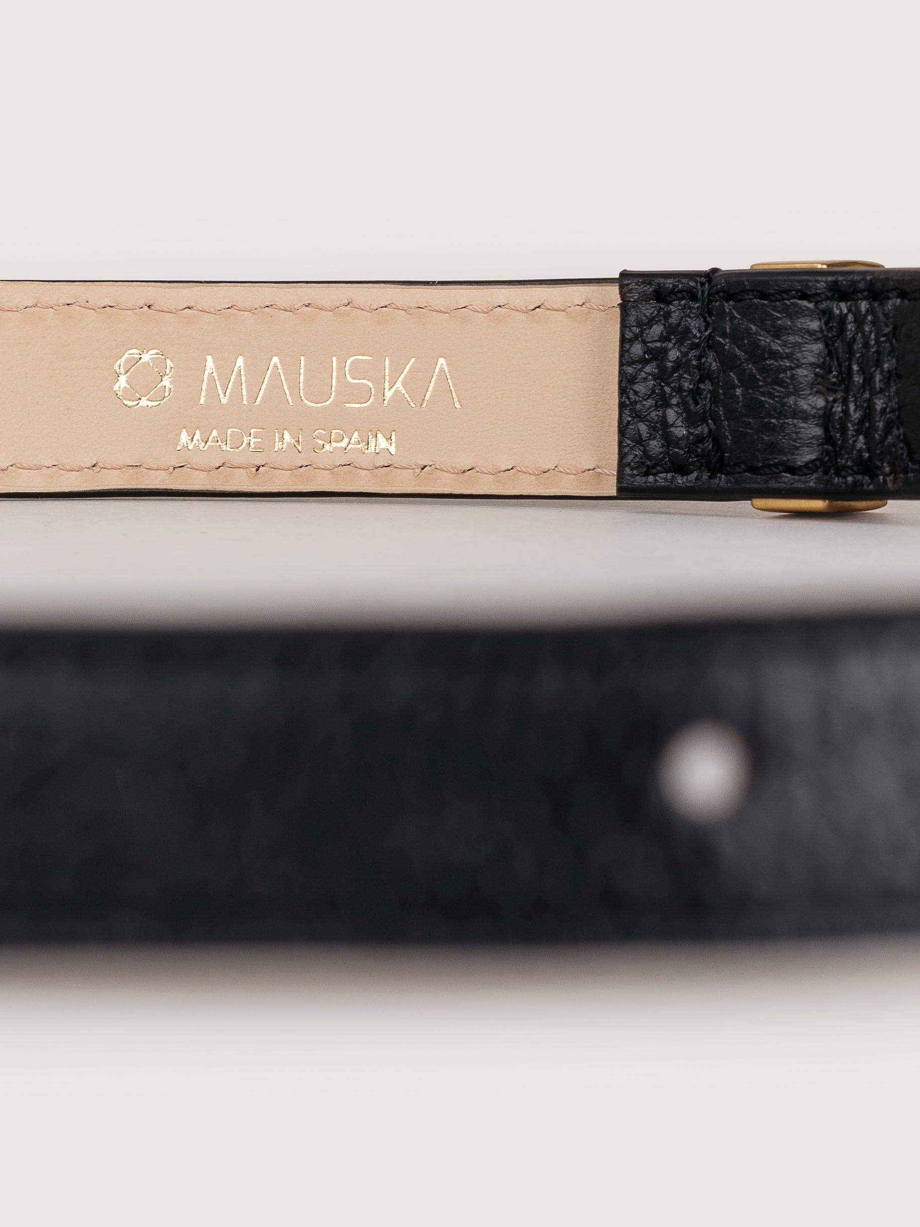Detailed view of the Louna calfskin leather belt by Mauska. Crafted with precision, this piece reflects refined materials and a clean, understated design. Designed in San Sebastián and made in Ubrique, Spain. Hand-painted edges and a polished buckle complete its finish.