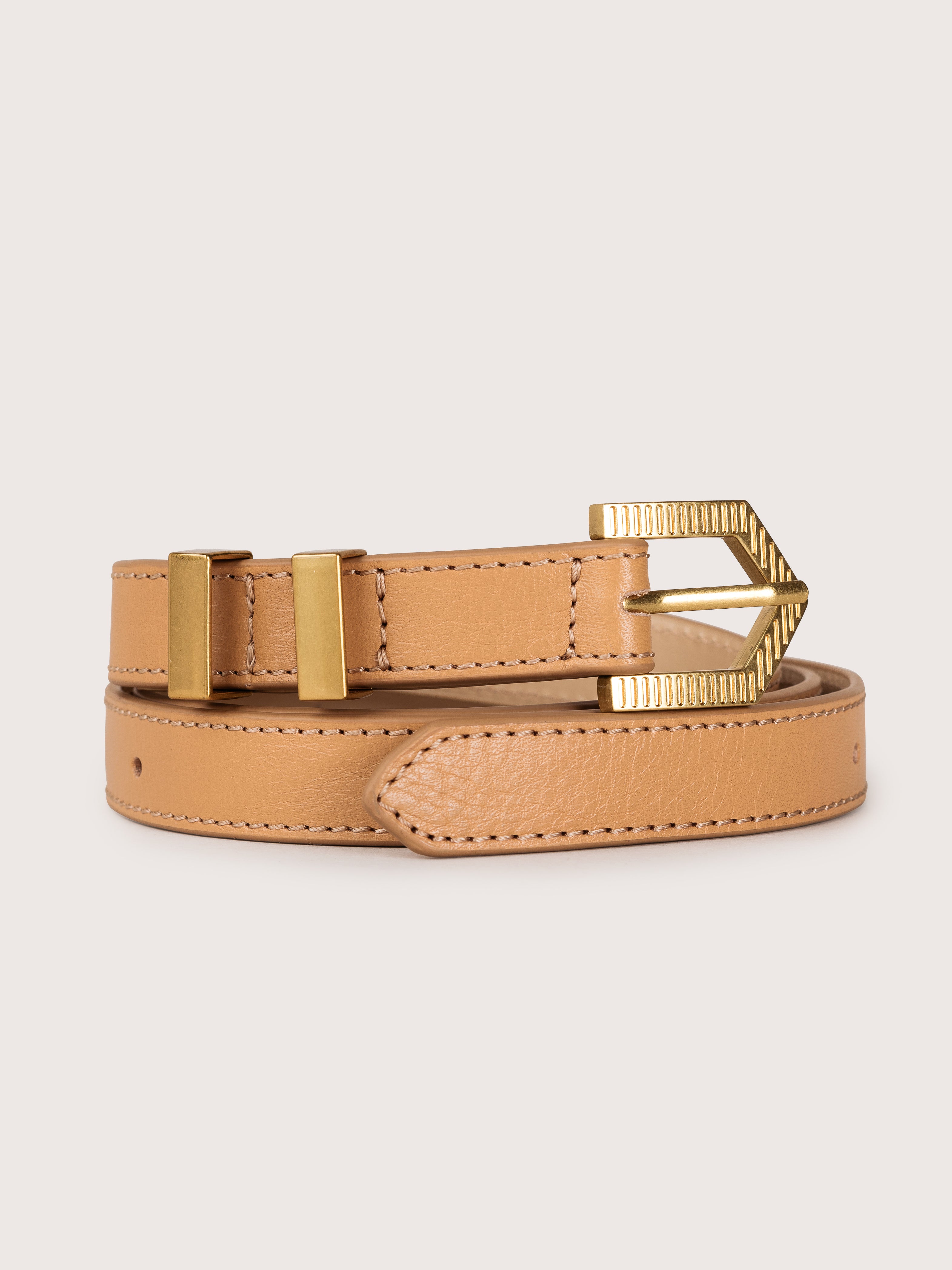 Detailed view of the Louna calfskin leather belt by Mauska. Crafted with precision, this piece reflects refined materials and a clean, understated design. Designed in San Sebastián and made in Ubrique, Spain. Hand-painted edges and a polished buckle complete its finish.