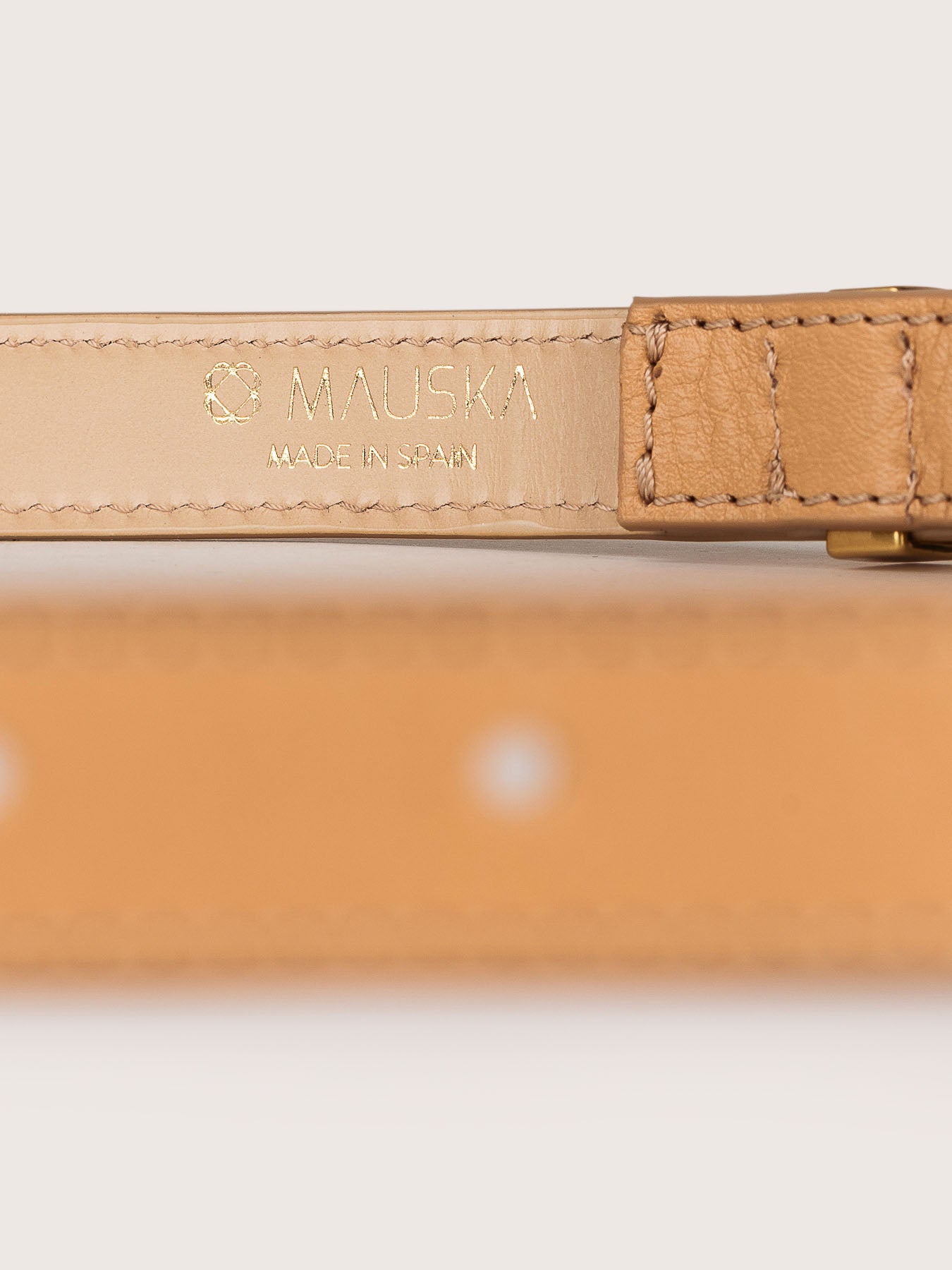Detailed view of the Louna calfskin leather belt by Mauska. Crafted with precision, this piece reflects refined materials and an understated design. Designed in San Sebastián and made in Spain. Hand-painted edges and a polished buckle complete its finish.