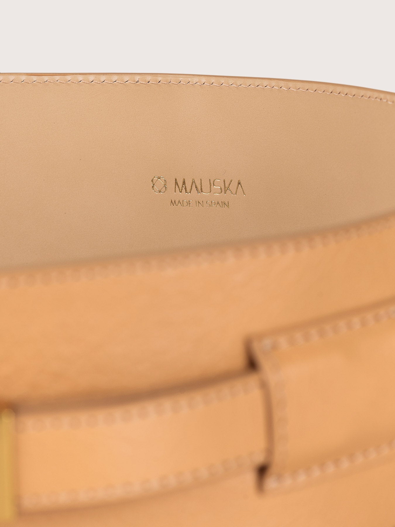 Close-up of the Louna Duo premium calfskin leather belt by Mauska. A fine leather goods accessory defined by its smooth texture, hand-painted edges and a refined metal buckle. Designed in San Sebastián and handcrafted in Ubrique, Spain.