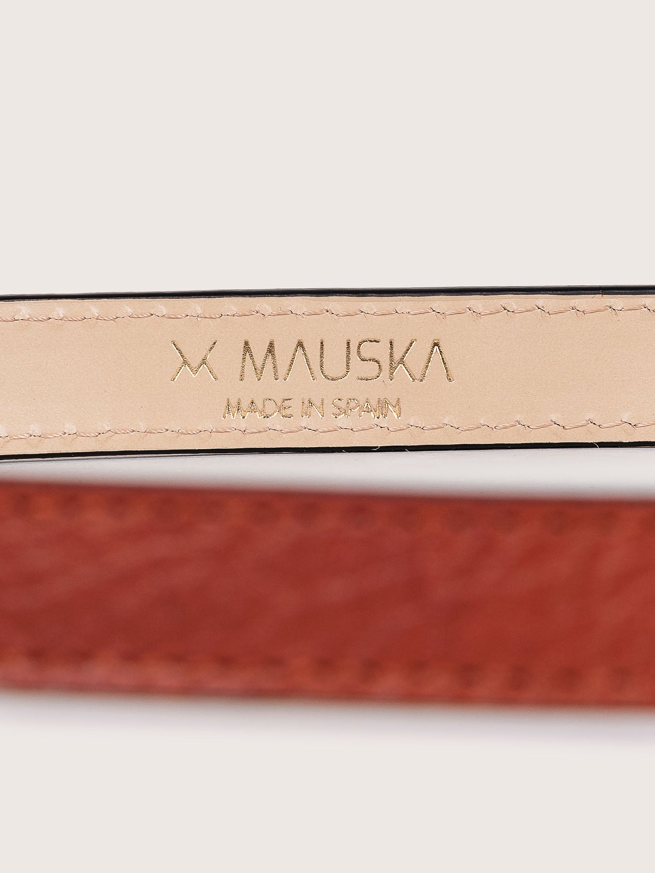 Detailed view of the Louna calfskin leather belt by Mauska. Crafted with precision, this piece reflects refined materials and a clean, understated design. Designed in San Sebastián and made in Ubrique, Spain. Hand-painted edges and a polished buckle complete its finish.