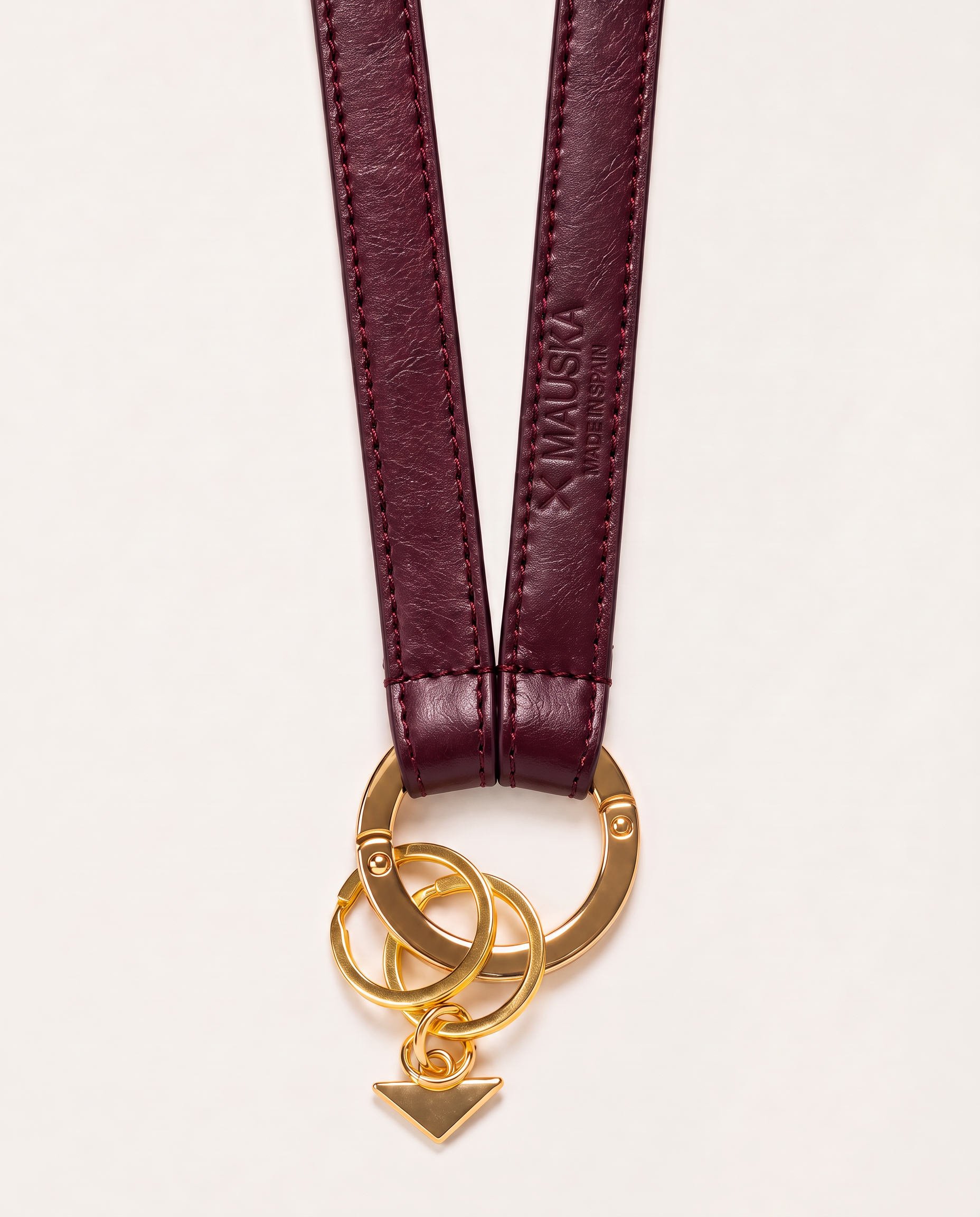 Back detail of MAUSKA ARO burgundy leather key holder showing embossed MAUSKA Made in Spain logo, stitching and gold-tone hardware