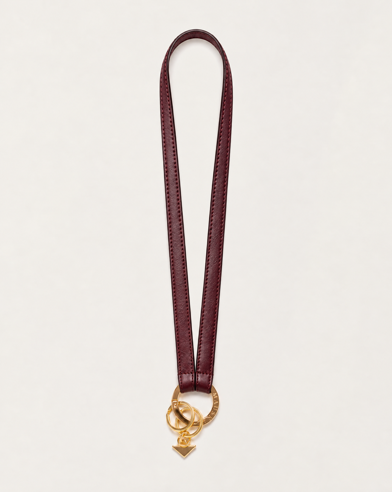 Full view of MAUSKA ARO burgundy vegetable-tanned leather neck key holder with gold-tone circular clasp and key rings