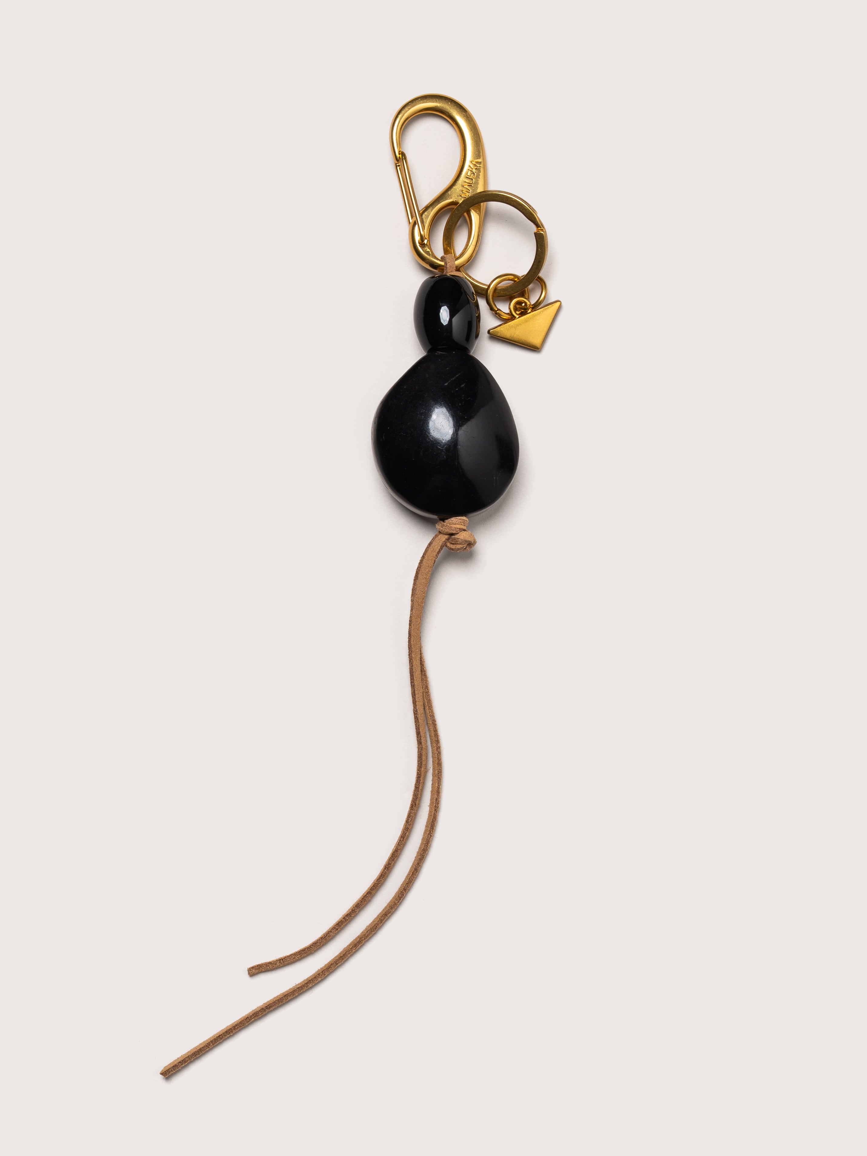 Detail of the Tagua leather key charm in black by Mauska. Luxury micro-leather accessory designed in San Sebastián and handcrafted by master artisans in Ubrique, Spain. Showcasing premium leather quality and high-end hardware finish.