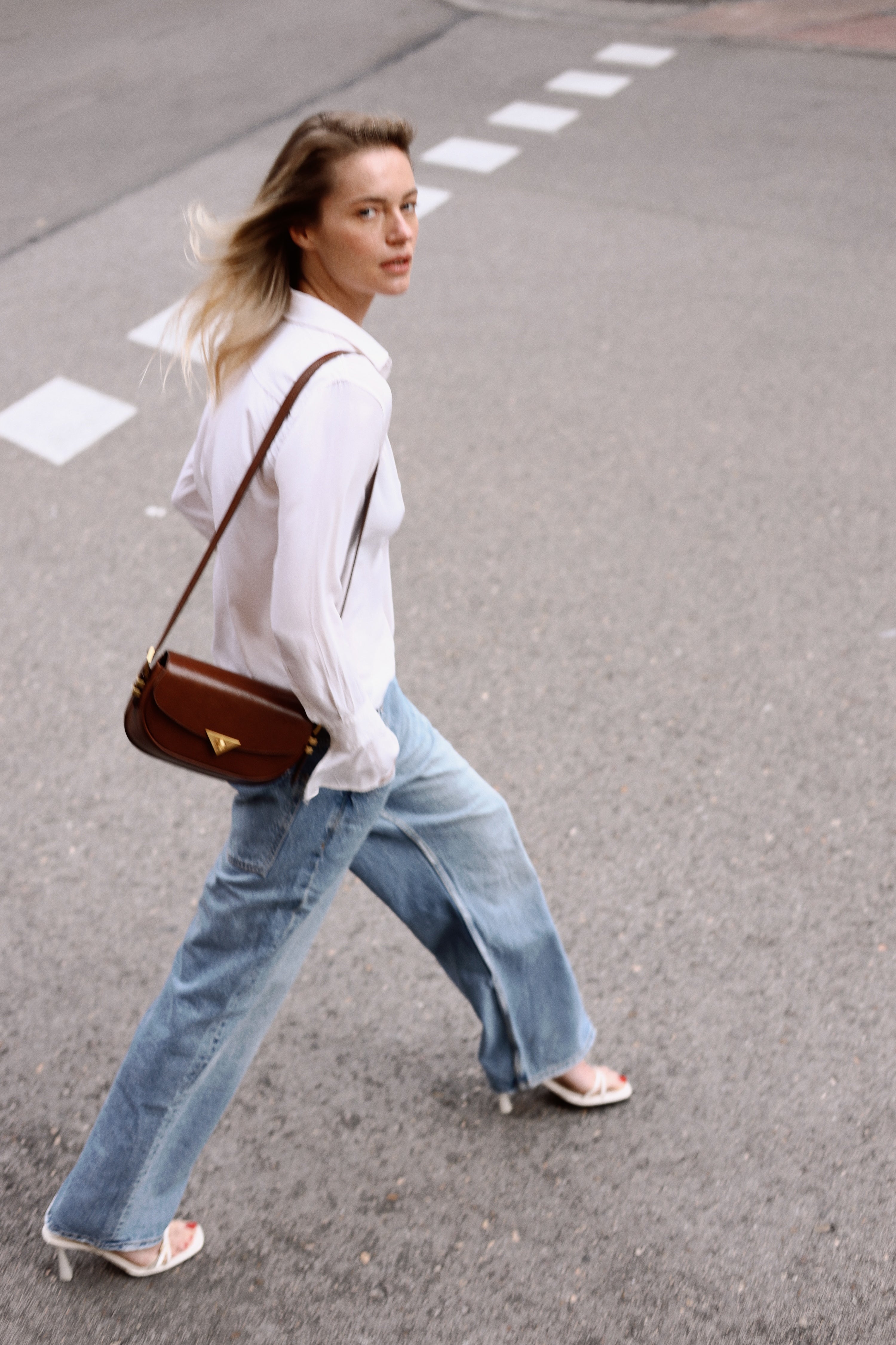 Castañuela hazelnut suede bag worn on model by Mauska. Designed in San Sebastián and handcrafted in Ubrique, Spain. Defined by texture and contemporary design.