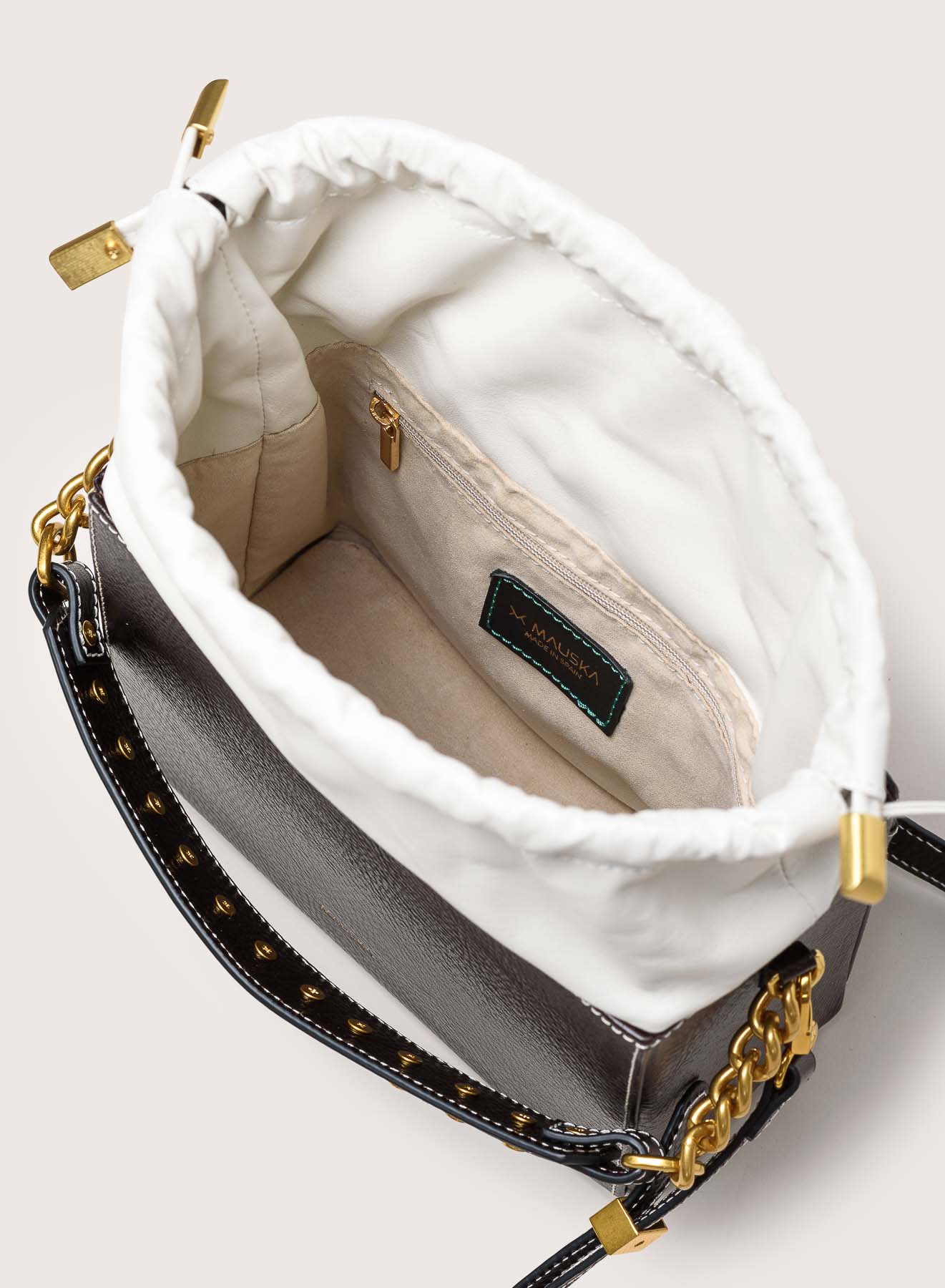 Interior view of the Colombo black and white leather bag by Mauska. A high-end leather accessory designed in San Sebastián and handcrafted in the workshops of Ubrique, Spain. Highlights the premium suede texture and contemporary designer silhouette.