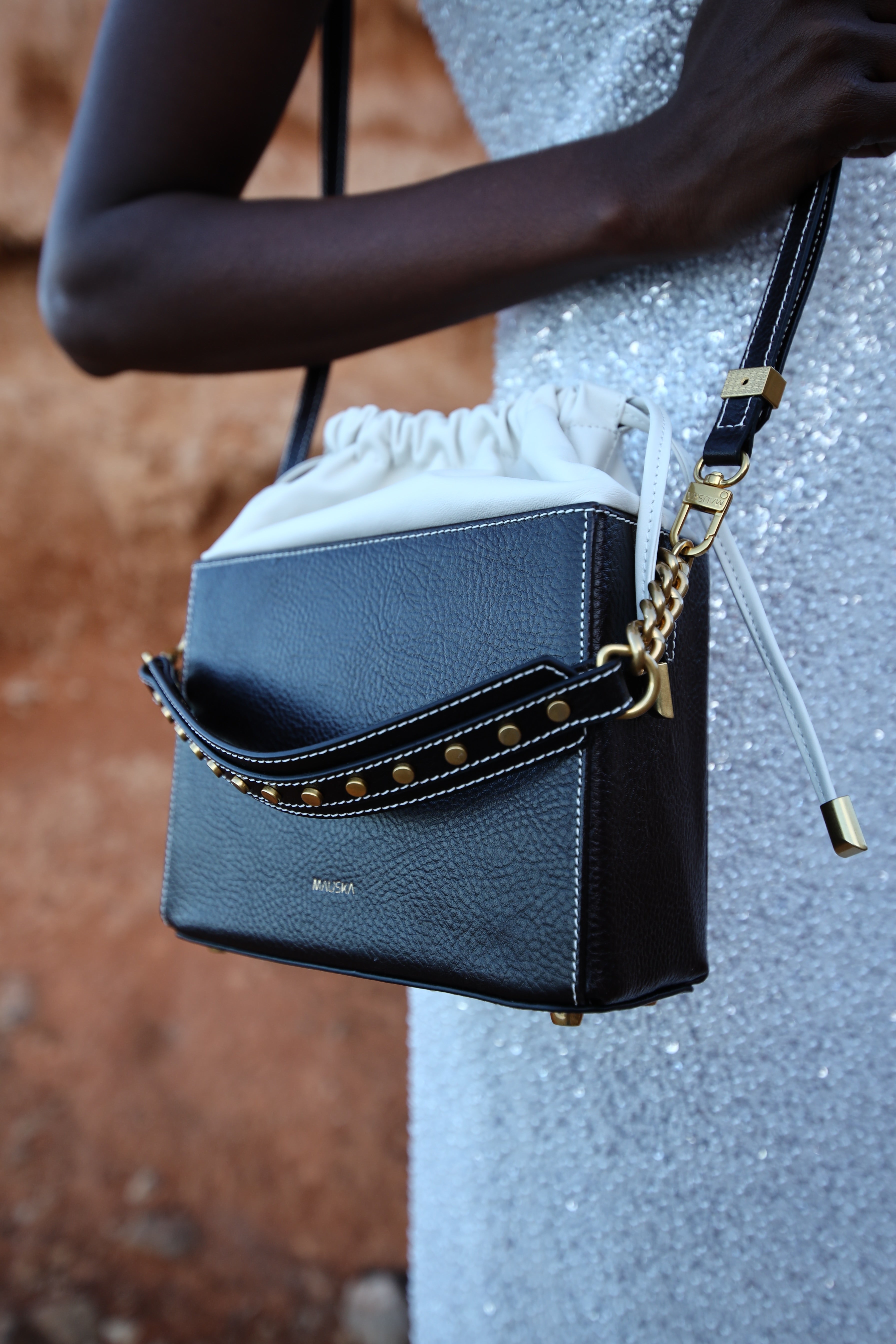 Styled view of the Colombo black and white suede leather bag by Mauska, handcrafted in Ubrique, Spain. Premium suede texture, contemporary designer silhouette, minimalist luxury accessory reflecting timeless understated elegance.