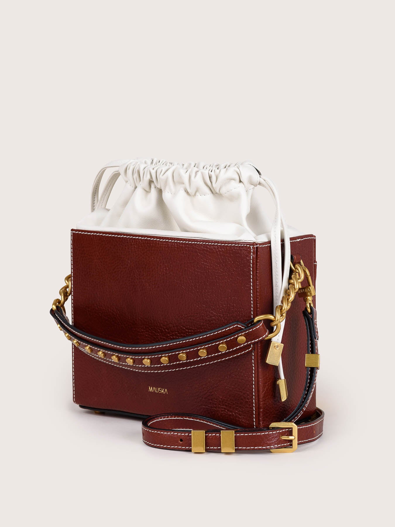 Side view of the Colombo cognac leather bag by Mauska. A high-end leather accessory designed in San Sebastián and handcrafted in the workshops of Ubrique, Spain. Highlights the premium leather texture and contemporary designer silhouette.