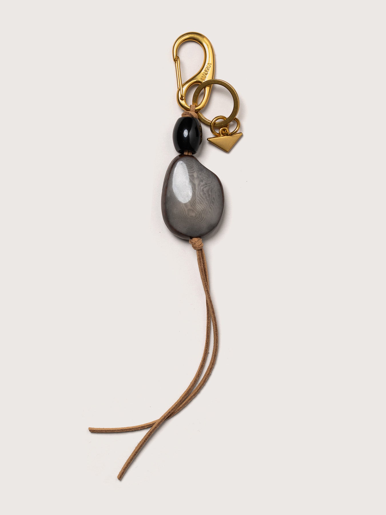 Detail of the Tagua leather key charm by Mauska. Luxury micro-leather accessory designed in San Sebastián and handcrafted by master artisans in Ubrique, Spain. Showcasing premium leather quality and high-end hardware finish.