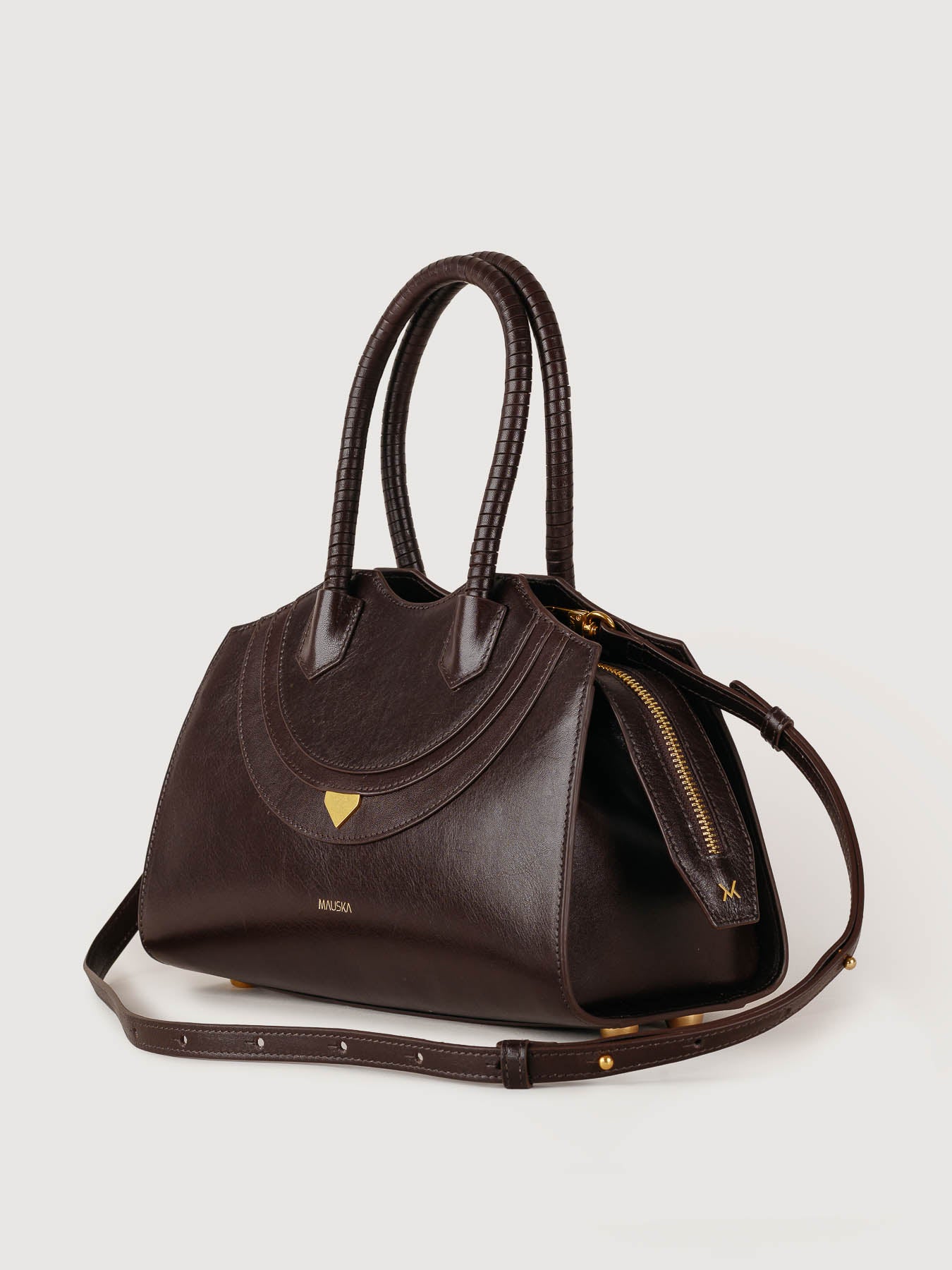 Side profile of Rosario bag in deep chocolate leather, minimalist silhouette, made in Spain