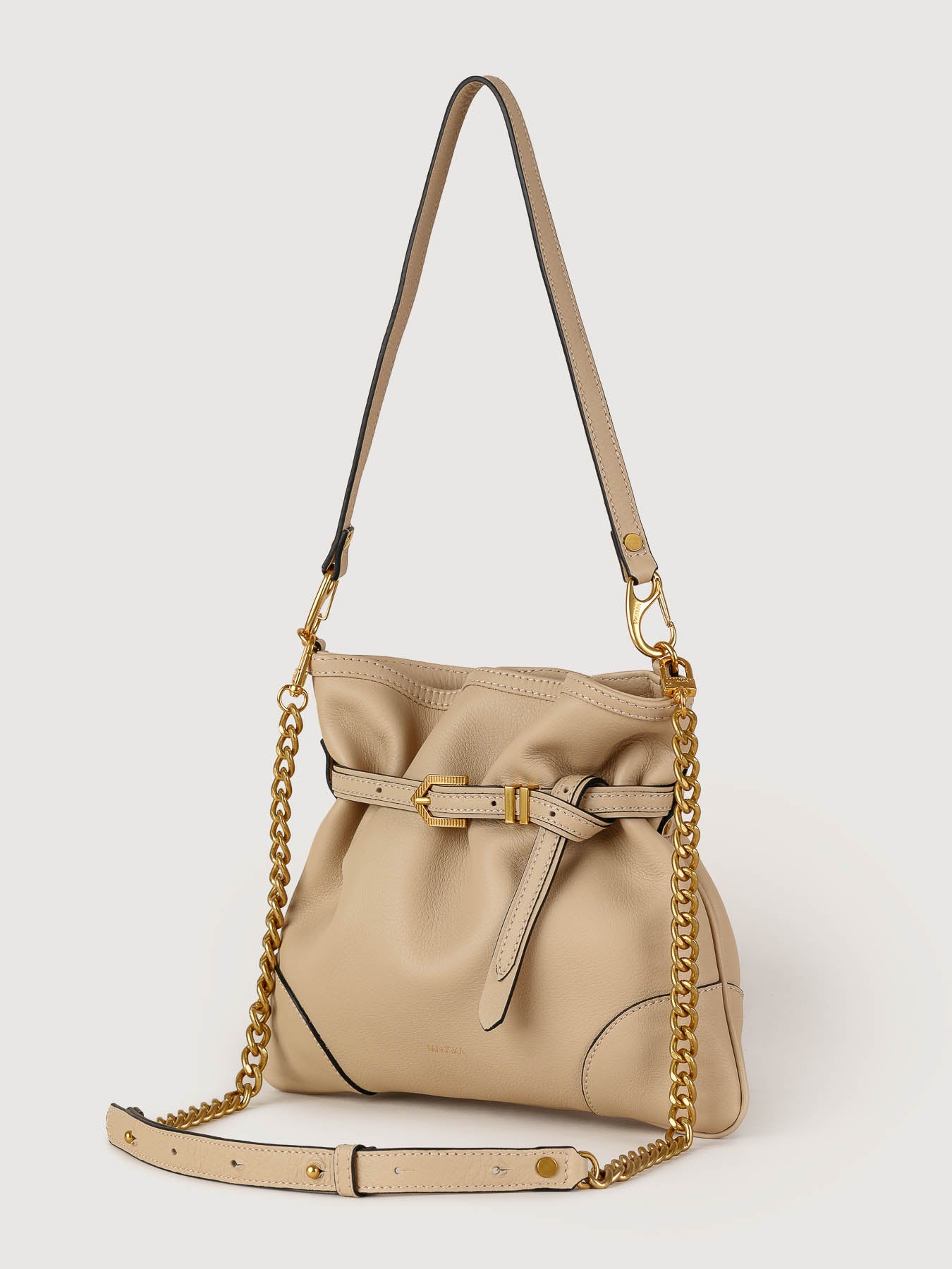 Side view of Pereira Mini beige leather bag showing its structured silhouette.
