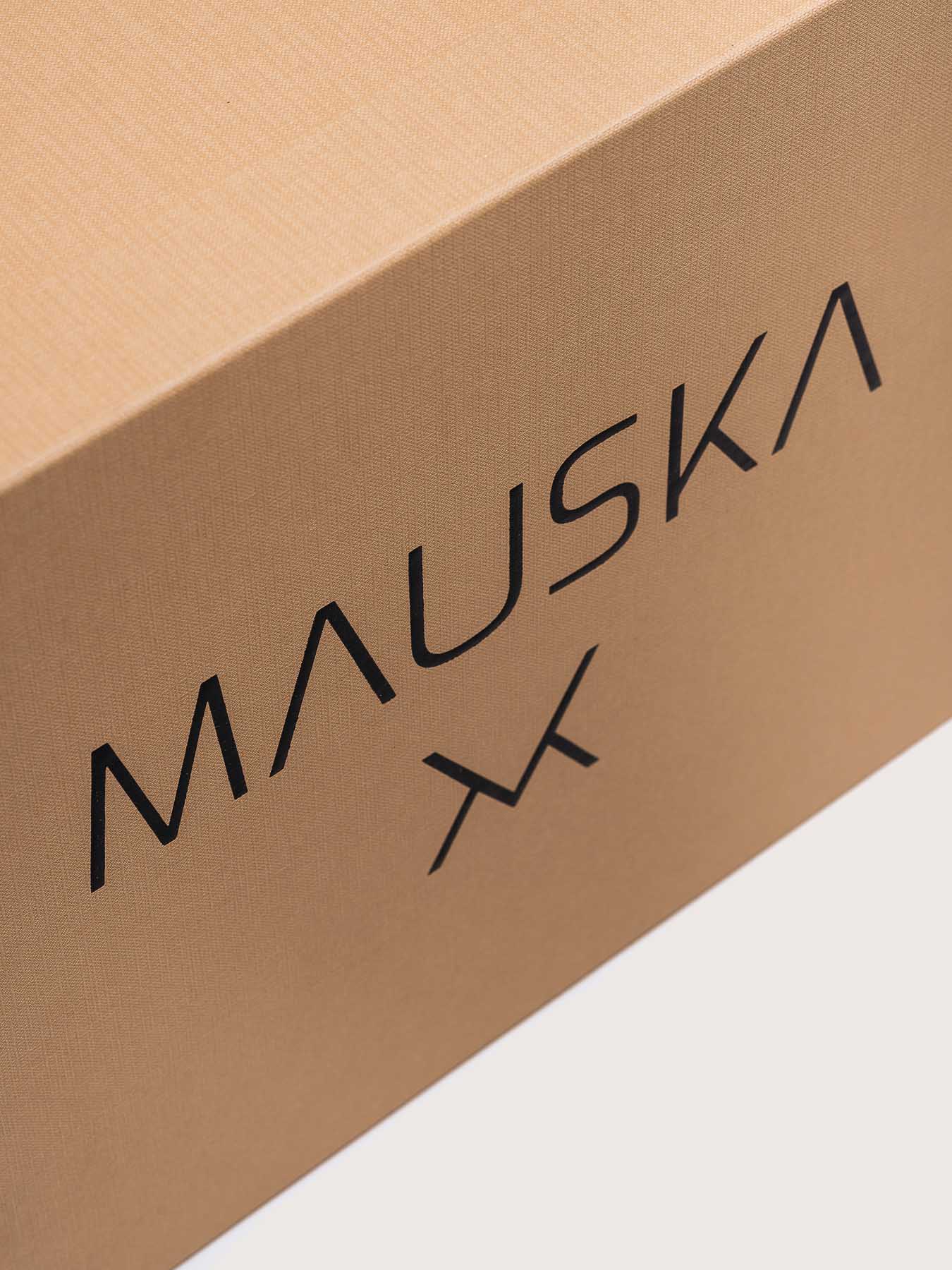 Close-up of the Louna Duo premium calfskin leather belt by Mauska. A fine leather goods accessory defined by its smooth texture, hand-painted edges and a refined metal buckle. Designed in San Sebastián and handcrafted in Ubrique, Spain.