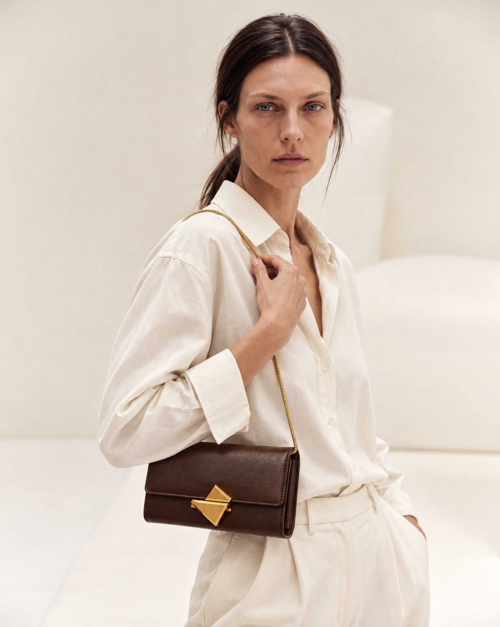 Model wearing the VEGA Clutch in Tobacco leather
