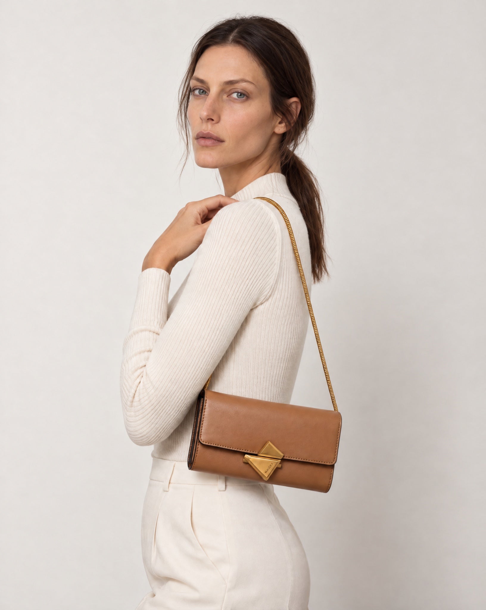 Model wearing the VEGA Clutch in natural leather