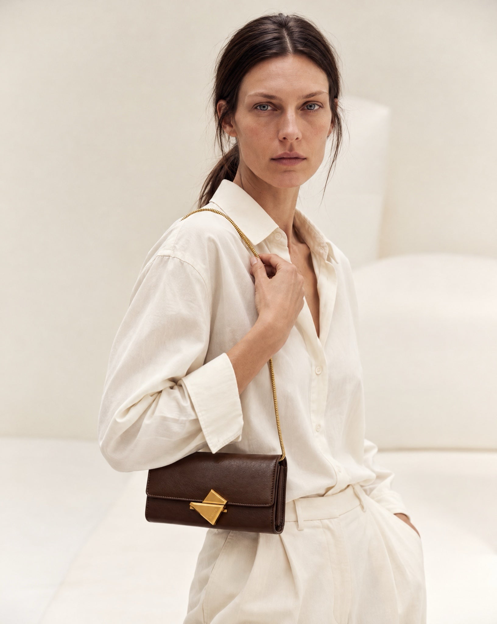 Model wearing the VEGA Clutch in tobacco leather